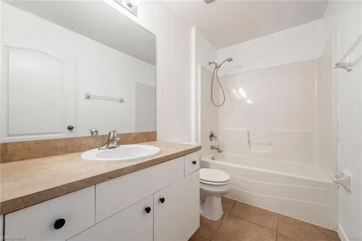 Bathroom featuring vanity, light tile patterned floors, and bathing tub / shower combination