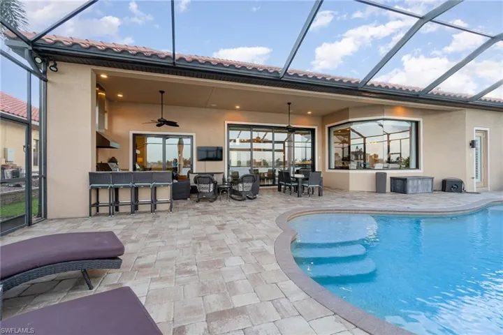 View of swimming pool featuring a patio, a lanai, and ceiling fan