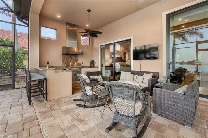 View of patio with an outdoor kitchen, ceiling fan, a grill, and an outdoor hangout area