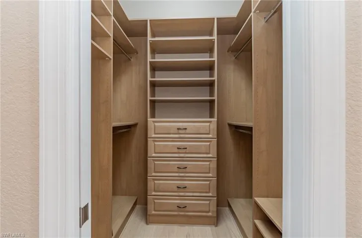Spacious closet with light hardwood / wood-style floors