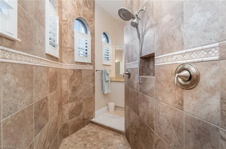 Bathroom featuring tile patterned flooring and a tile shower