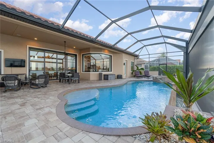 View of swimming pool with a patio and glass enclosure