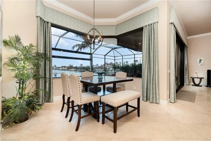 Dining area with a chandelier, a water view, and crown molding