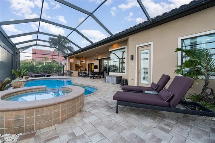 View of swimming pool with a lanai, an in ground hot tub, and a patio area