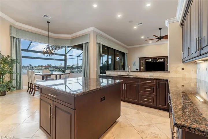 Kitchen with pendant lighting, sink, a center island, and crown molding