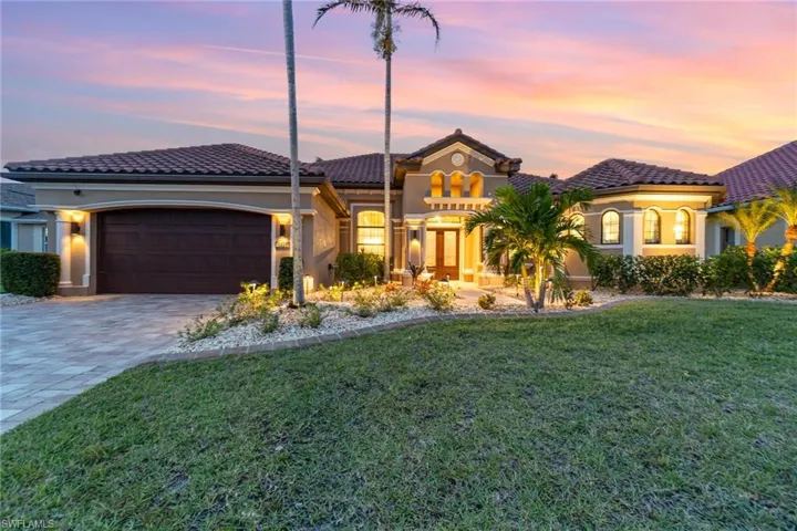 Mediterranean / spanish-style house featuring a garage and a yard