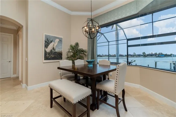 Dining room featuring ornamental molding, a wealth of natural light, and a water view