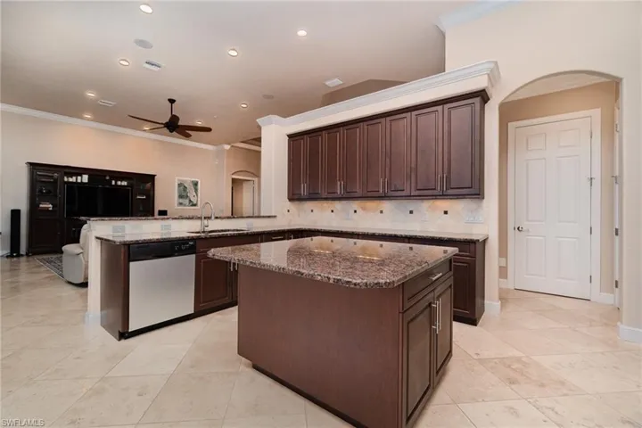 Kitchen with a center island, dishwasher, kitchen peninsula, sink, and crown molding