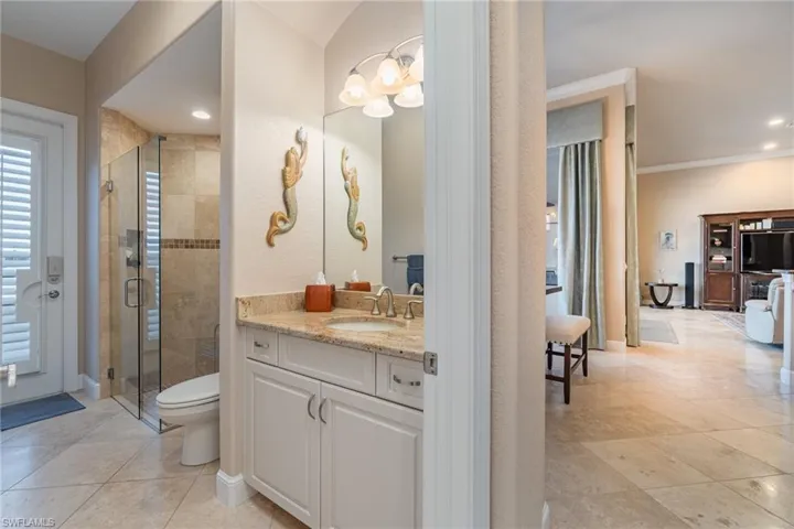Bathroom featuring walk in shower, ornamental molding, vanity, tile patterned floors, and toilet