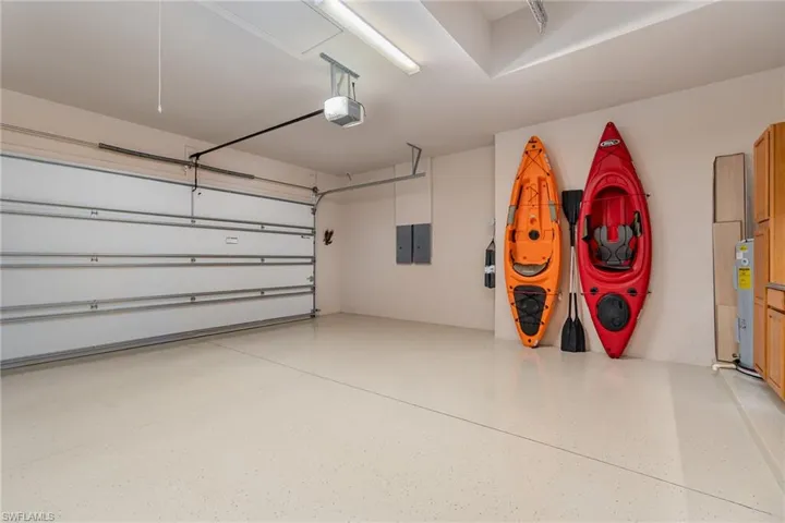 Garage with electric water heater, a garage door opener, and electric panel
