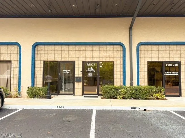 View of exterior entry with stucco siding and uncovered parking