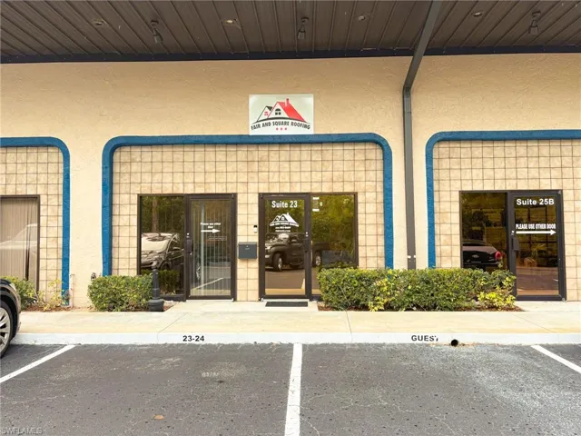 View of exterior entry with stucco siding and uncovered parking