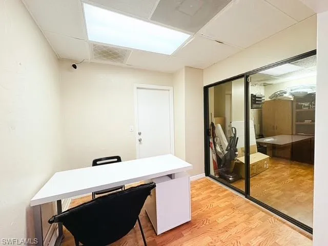 Office space with light wood-style flooring and a paneled ceiling