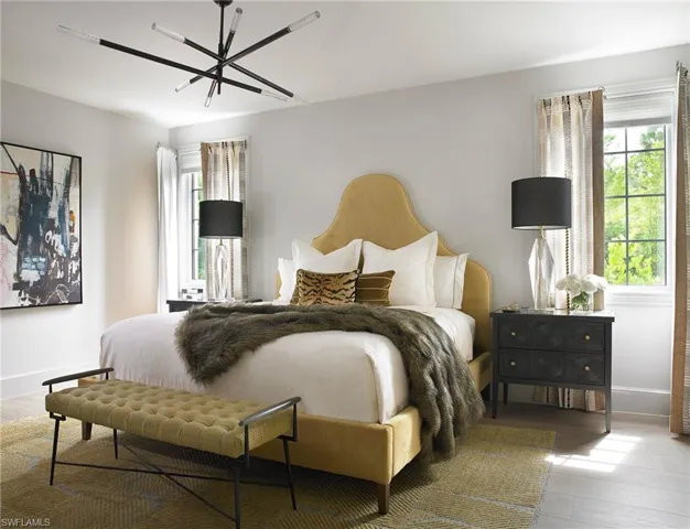 Bedroom featuring multiple windows, hardwood / wood-style flooring, and an inviting chandelier