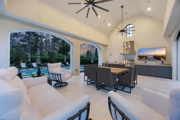 View of patio featuring exterior kitchen, a ceiling fan, an outdoor living space, outdoor dining area, and an outdoor pool