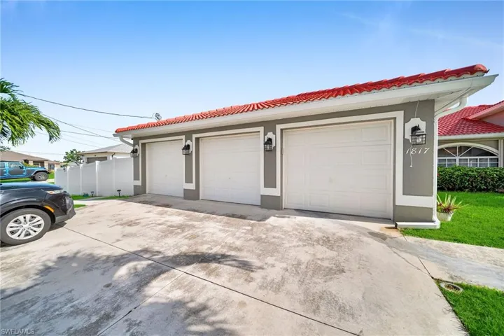 View of front facade featuring stucco siding, a tile roof, and a garage