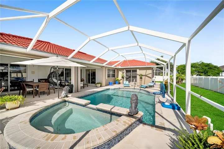 View of swimming pool featuring a sunroom, a pool with connected hot tub, a patio, and a lanai