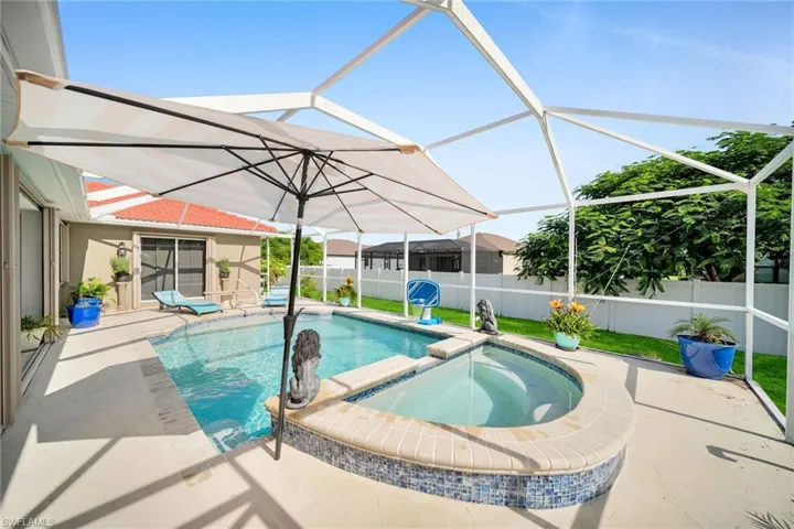 View of pool with a sunroom, a pool with connected hot tub, a patio area, and a lanai