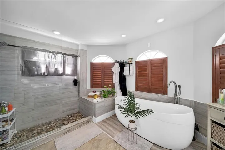 Full bathroom featuring a soaking tub, walk in shower, and recessed lighting
