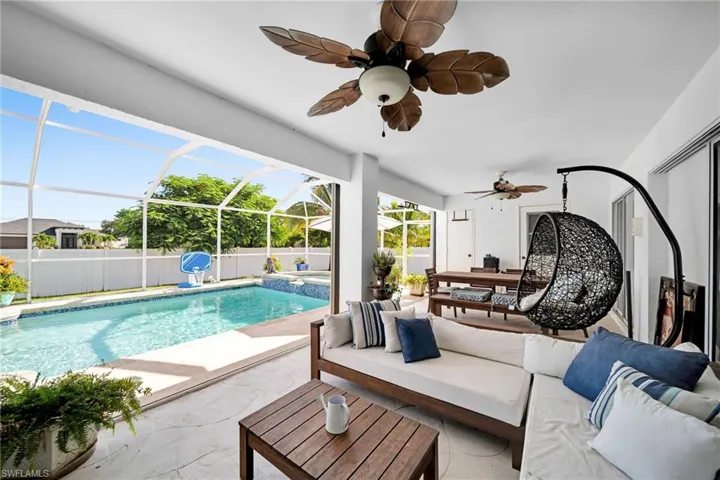 View of swimming pool with an outdoor hangout area, a sunroom, a patio area, a pool with connected hot tub, and a fenced backyard