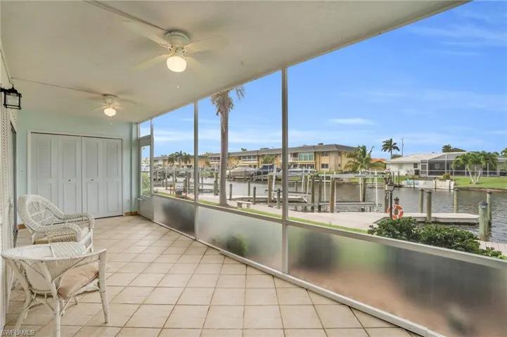 Unfurnished sunroom featuring ceiling fan and a water view