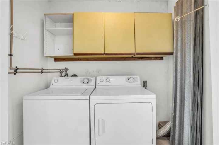 Clothes washing area with cabinets, independent washer and dryer, and washer hookup