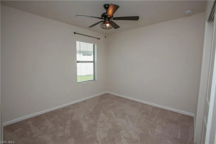Empty room with carpet floors and a ceiling fan