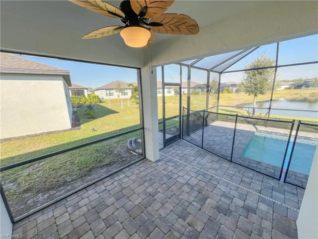 Unfurnished sunroom featuring a water view and ceiling fan