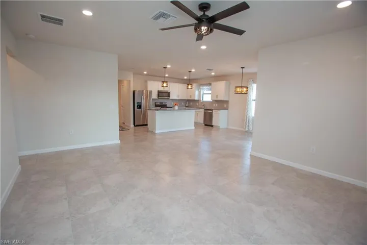 Unfurnished living room featuring a ceiling fan and recessed lighting