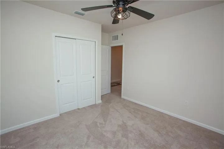 Unfurnished bedroom with light colored carpet, a closet, and ceiling fan