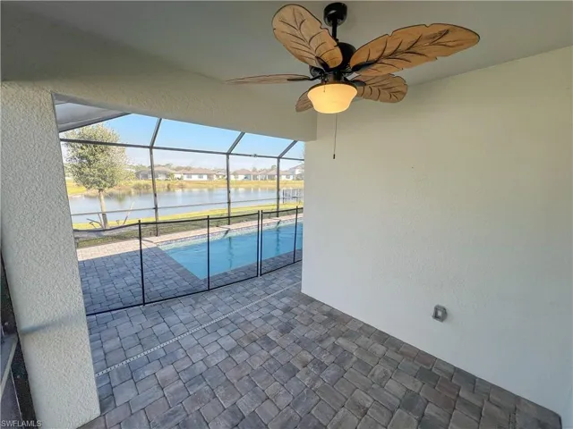 Outdoor pool featuring a ceiling fan, a water view, a lanai, and a patio area