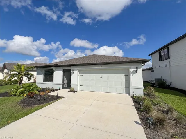 View of front of property with a garage, driveway, stucco siding, and central air condition unit