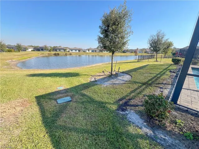 View of yard with a water view and fence