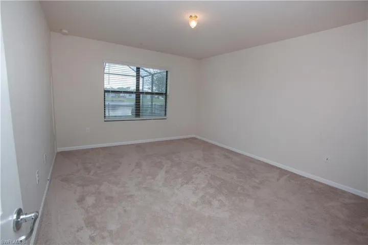 Empty room featuring carpet and baseboards