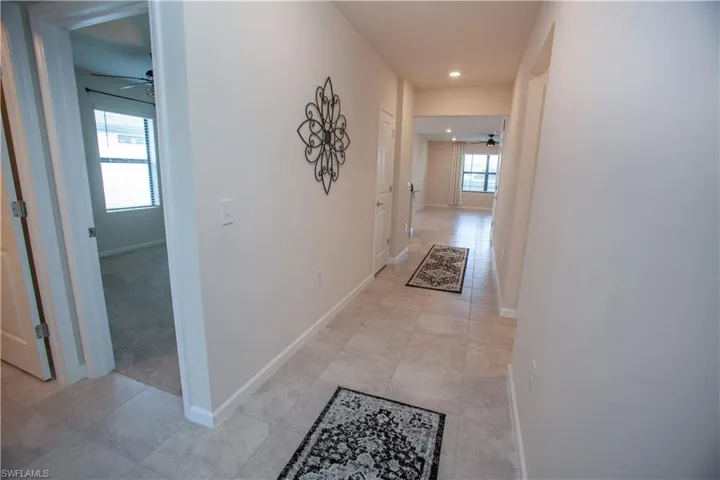 Corridor with light tile patterned flooring and recessed lighting