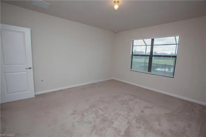 Carpeted empty room featuring baseboards