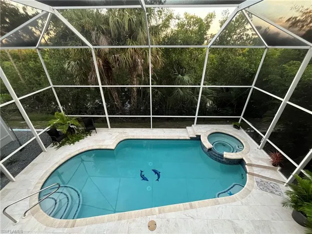Large 2 story screen enclosure with a heated pool and spa.