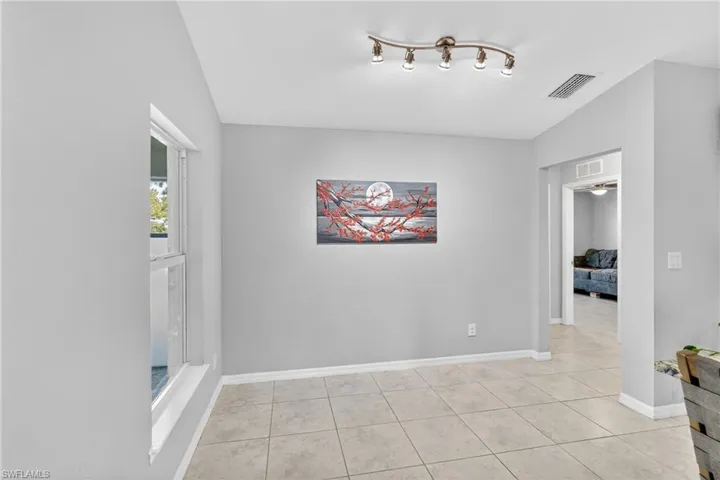 Unfurnished room featuring lofted ceiling and light tile patterned floors
