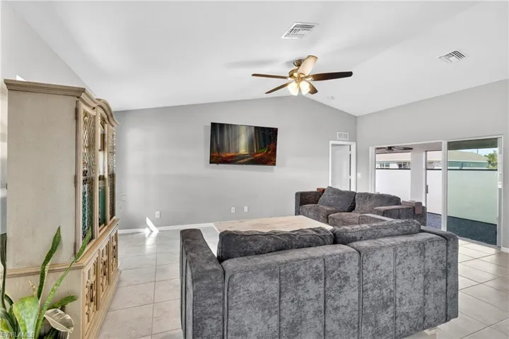 Living area featuring a ceiling fan and light tile patterned floors