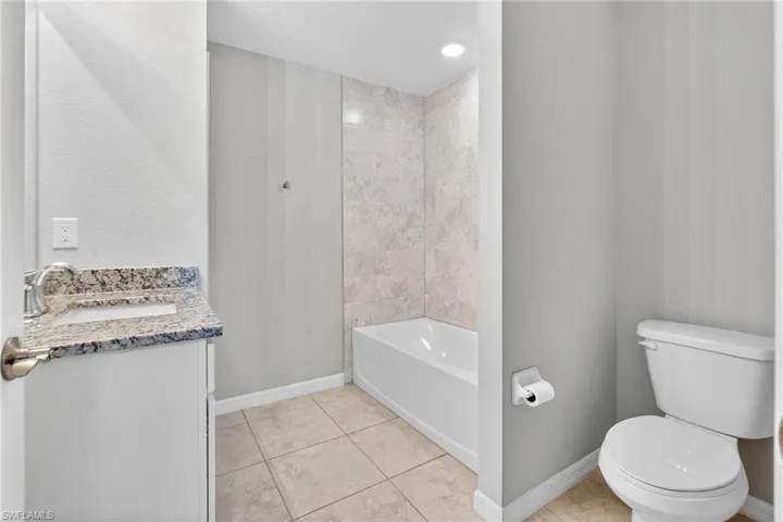 Bathroom featuring vanity, light tile patterned floors, a bathtub, and a shower