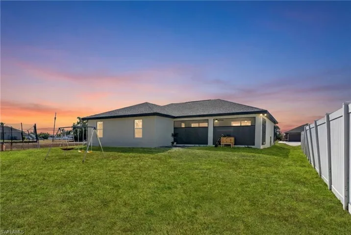 Rear view of house featuring a fenced backyard and stucco siding