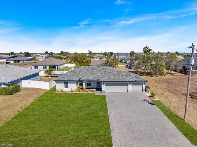 Ranch-style house featuring an attached garage, a residential view, and driveway