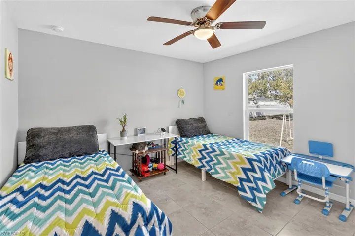 Bedroom with ceiling fan and light tile patterned floors