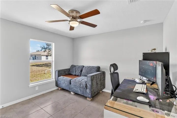 Tiled office with ceiling fan and a textured ceiling
