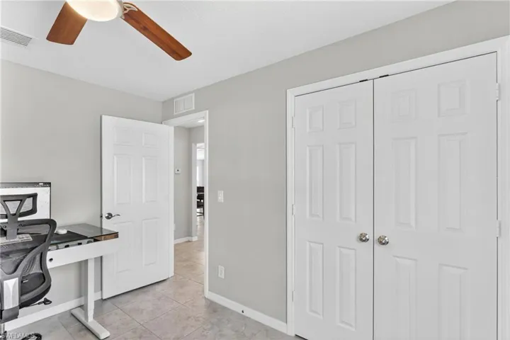 Office featuring a ceiling fan and light tile patterned flooring