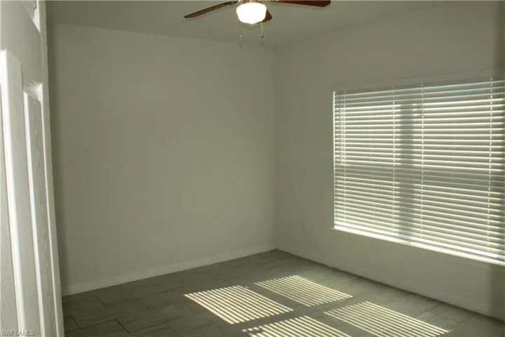 Empty room with a ceiling fan and wood finished floors