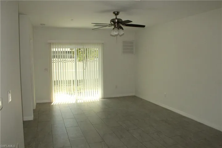 Empty room featuring a ceiling fan and baseboards