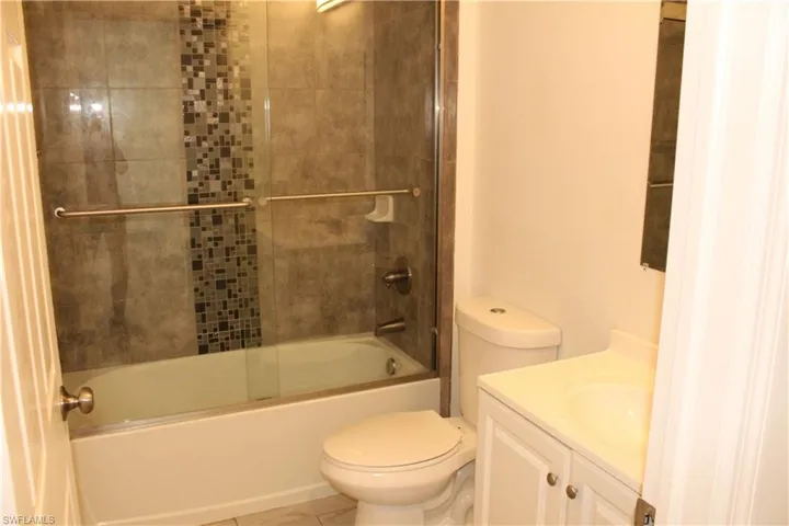 Bathroom with vanity and shower / bath combination with glass door