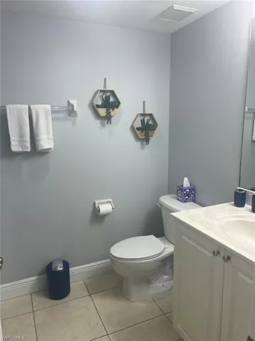 Bathroom featuring a vanity with an integrated basin, a light-toned countertop, and tile flooring