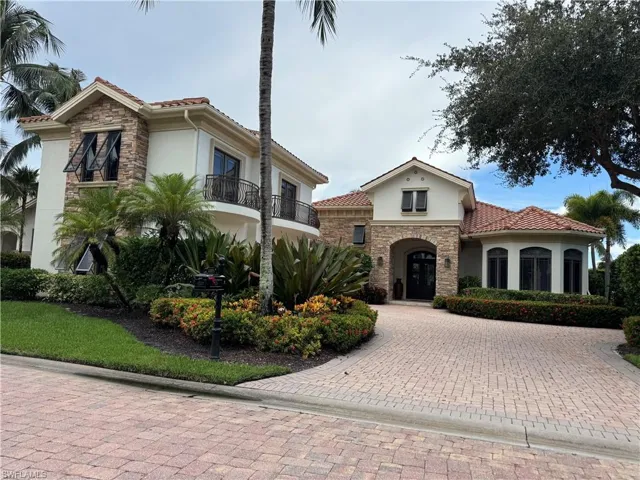 Mediterranean / spanish home featuring stucco siding, a tiled roof, stone siding, decorative driveway, and a balcony